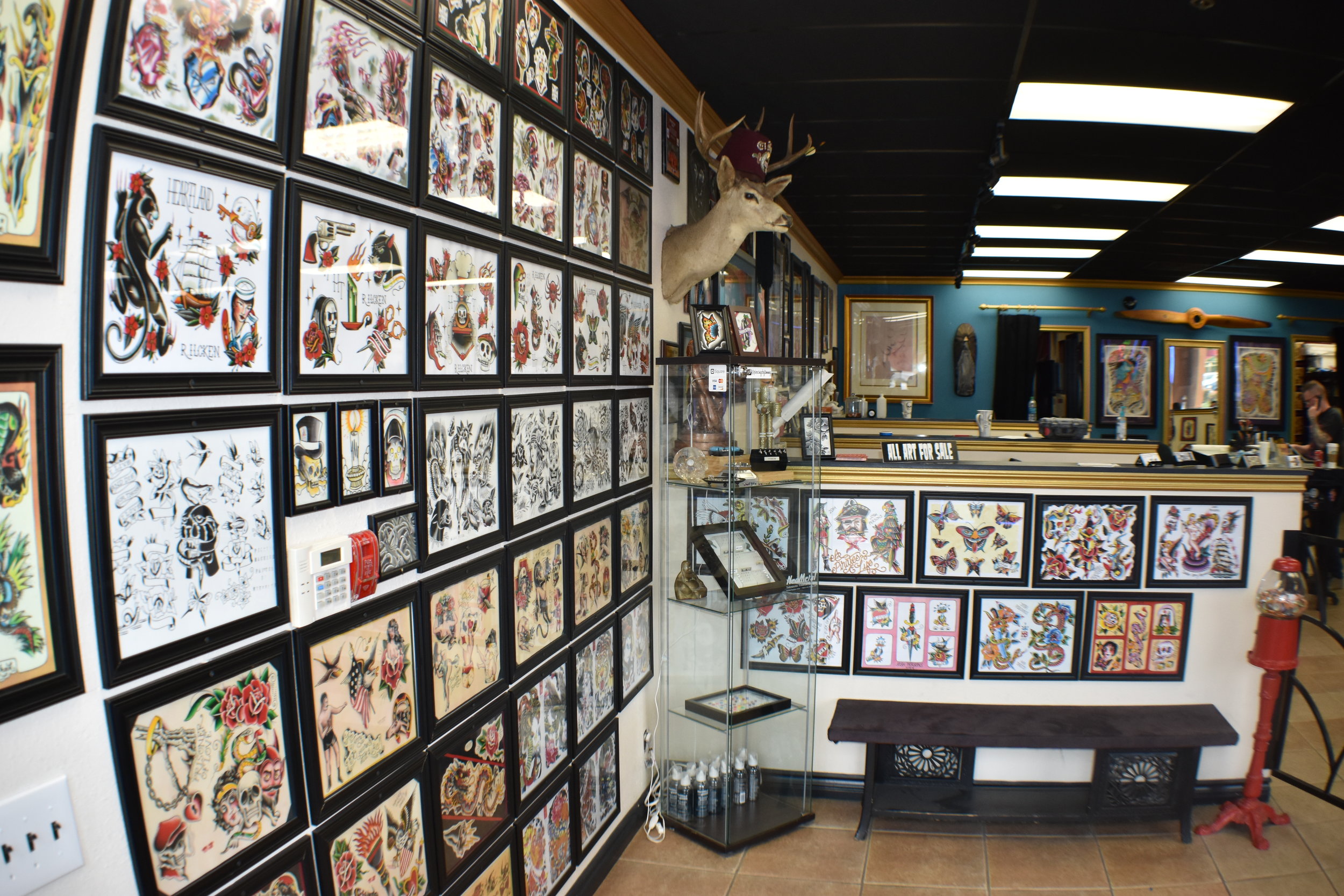 Inside Breakthrough Tattoo in Upland, CA with the walls covered in traditional art that clients can choose from.